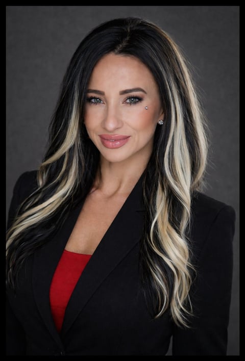 Professional headshot of Krystal, co-founder of Restoration Living, with long black and blonde highlighted hair wearing a black blazer